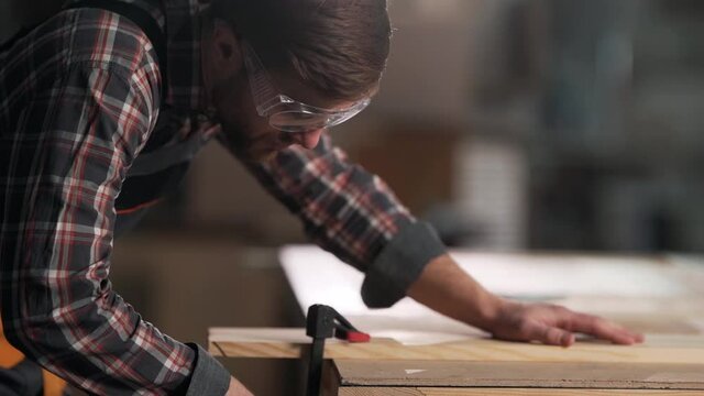 Closeup portrait of carpenter clamping carpentry board