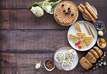 Flat layot from  festive dessert table with various of waffles, cake, muffins and sweets.