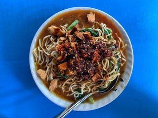 Chicken noodles topped with diced chicken, spinach vegetables and Chili sauce . Jakarta's typical Chicken Noodle. Called 
