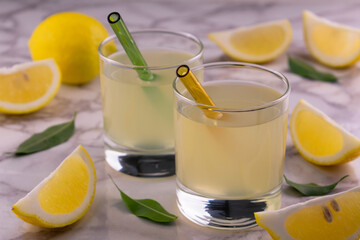 Two glasses with lemon juice on a marble background.
Close-up.