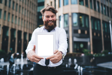 Happy bearded man showing tablet screen