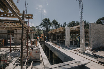 Construction site of multi-storey building with concrete slabs and columns. Men at work .