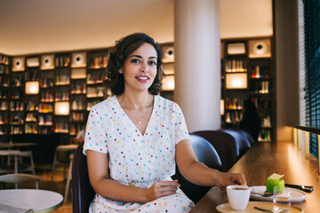 Stylish woman enjoying coffee in cozy cafe