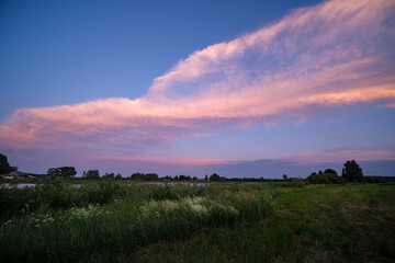 country landscape with green meadow and blue sky above