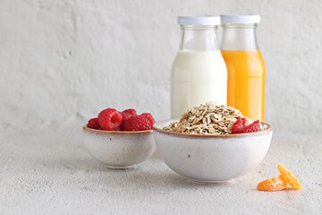 Healthy breakfast with Muesli cereal mix, milk, orange juice and fresh raspberries . Close up, copy space