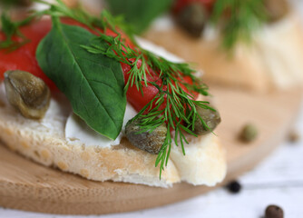 small sandwich with red fish, cream cheese, fresh spinach and capers 