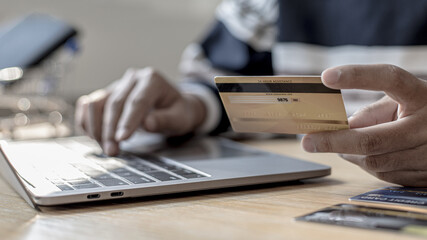 Woman's finger presses a keyboard and holds a credit card to register for payment or online transactions, Financial transactions and Internet security, Shopping online and banking online concept.