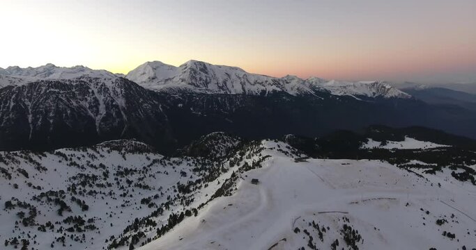 Chamrousse ski resort track summit with cabin in the French Alps during sunrise, Aerial orbit left reveal shot