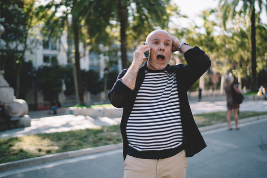 Emotional male tourist with expression on face remember something important during cellphone conversation in roaming, aged Caucasian man forgot connect roaming service during travel journey
