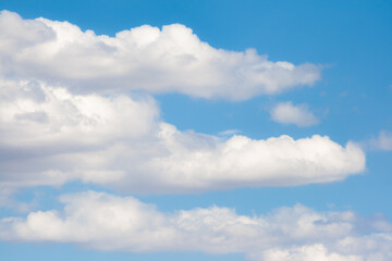 Three scattered cloud clusters with a nice blue sky in the background