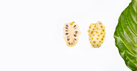 Noni or Morinda Citrifolia fruits with cut and green leaf isolated on white background