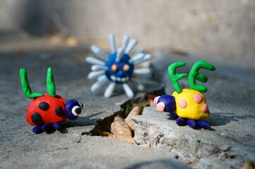 Obraz premium Figurines of two ladybirds made of plasticine. The figures are placed opposite each other. There's a crack between them. Next to it is the inscription life. In the background, the figure of the virus.