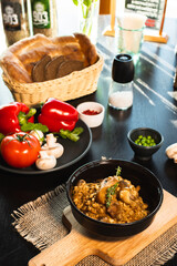 Pearl barley risotto or orzotto with mushrooms in dark bowl on wooden background. Selective focus.