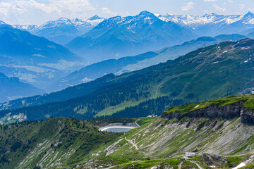 Scenic skyline of snowy mountain tops and green wooded mountainsides.