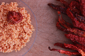 Turkish traditional food , fine bulgur with red hot chilies  on wooden table. Selective focus.