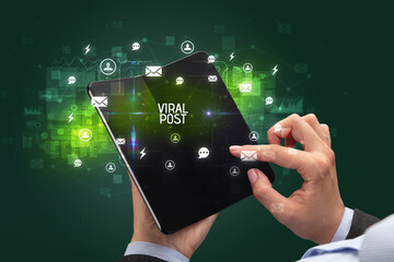 Businessman holding a foldable smartphone, social media concept