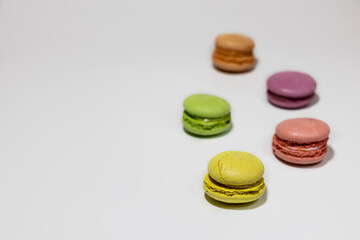 Colorful macaroon cookies on a white background in perspective.