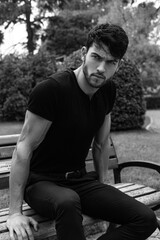 Obraz premium serious bearded man with muscles sitting on the bench in a park in istanbul