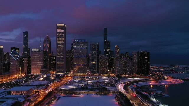 Urban Cityscape of Chicago Loop at Night in Winter. New Eastside and Lake Michigan. Blue Hour. Aerial View. United States of America. Drone Flies Forward