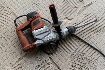 Old electric drill, gray background, rotary hammer