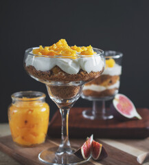 macro photo of tiramesu dessert with orange curd on a black background