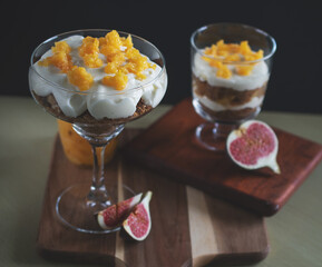 macro photo of tiramesu dessert with orange curd on a black background