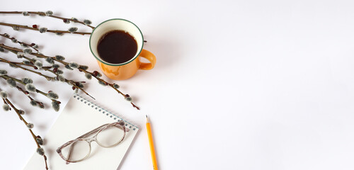 Banner :yellow cup of hot tea, willow branches, notepad, pencil, glasses for vision on a white background, space for text, view of the swer
