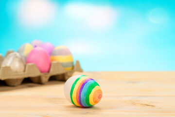 Colorful easter eggs on a stand on a table on a blue background with place for text