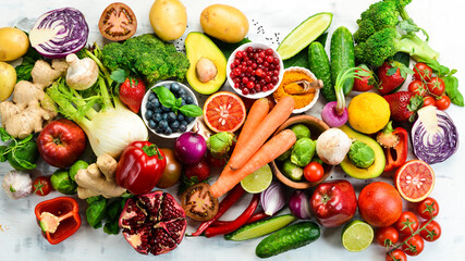 Vegan food banner. Fresh vegetables and fruits and berries on a white wooden background. Free space for your text.