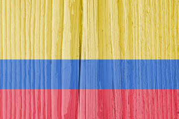 The flag of Colombia on dry wooden surface, cracked with age. Light pale faded paint. Background, wallpaper or backdrop with Colombian national symbol. Old wood. Hard sunlight with shadows