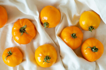 Yellow tomatoes on linen background. Top view.