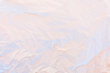 Crumpled paper in pastel pink and blue neon lights texture background