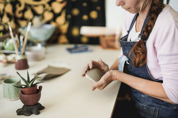 Woman work in creative ceramic pottery studio with clay - Concept of handcraft - Focus on the hands