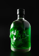 Green skull absinthe bottle on dark background