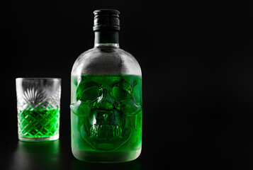 Green skull absinthe bottle on dark background