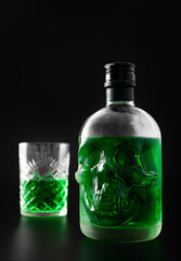 Green skull absinthe bottle on dark background