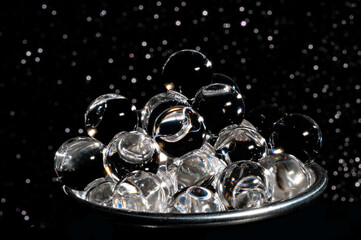 Gray caviar cup in glittered black background close-up view
