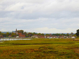 Flood area with low green vegetation, water, sailboats and buildings