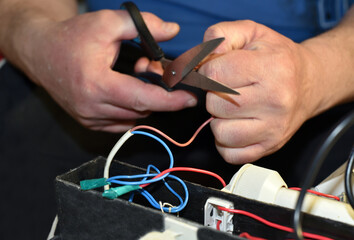 Electrician at work. Looks for a malfunction in the lighting equipment.
