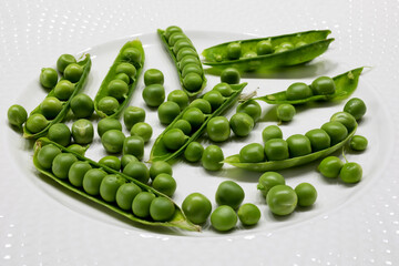Fresh green peas on a white plate. Healthy and tasty food.
