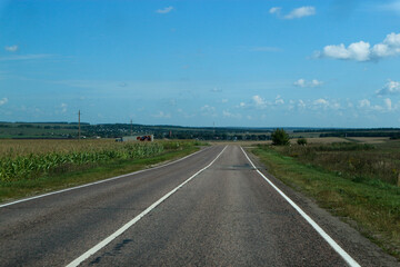 asphalt road in the countryside surrounded by field, russian outback