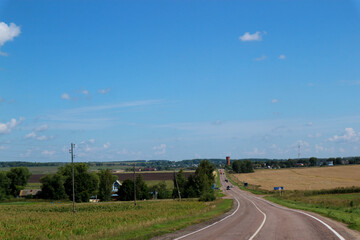 asphalt road in the countryside surrounded by field, russian outback