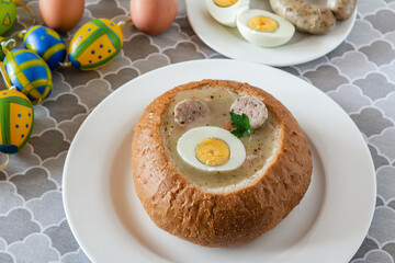 The sour soup (zurek) made of rye flour with sausage and egg served in bread bowl. Popular Easter dish.
