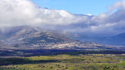 Aerial view green mountain landscape with dark clouds and villages with houses on the mountainside. Navacerrada Madrid.