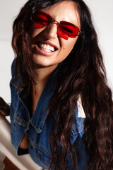 Naklejka premium pretty caucasian brunette woman in red sunglasses smile with white teeth