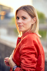 Outdoor portrait of beautiful woman wearing red jacket.