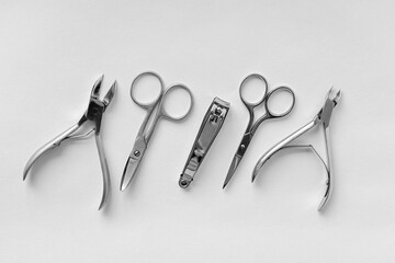 A set of cosmetic tools for manicure and pedicure on a light background. Nail file, nail scissors,...