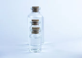 Gordijnen Glazen apotheekflessen met vloeistof op blauwe achtergrond. © Albert Ziganshin