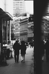 London UK February 2021 Black and white vertical shot of a couple walking the streets of london on Valentines day, together on a cold winter day