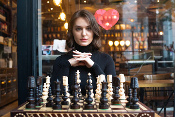 Beautiful girl play chess, queen’s gambit play and everyone wins, smart and pensive face. White...